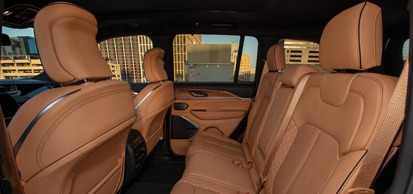 Display The second row of a 2024 Jeep Grand Cherokee Summit Reserve with highrise buildings in the background.