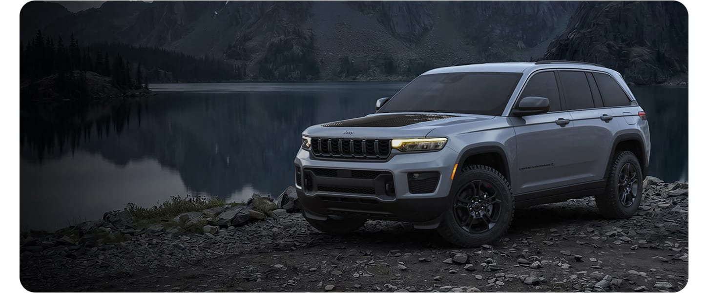 Gray Jeep Grand Cherokee Laredo Upland parked beside a lake