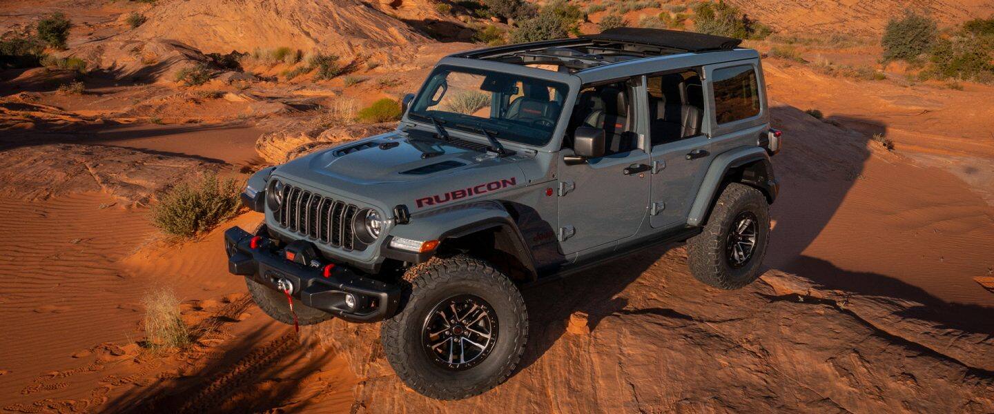 The 2021 Jeep Wrangler Rubicon being driven past a lake.