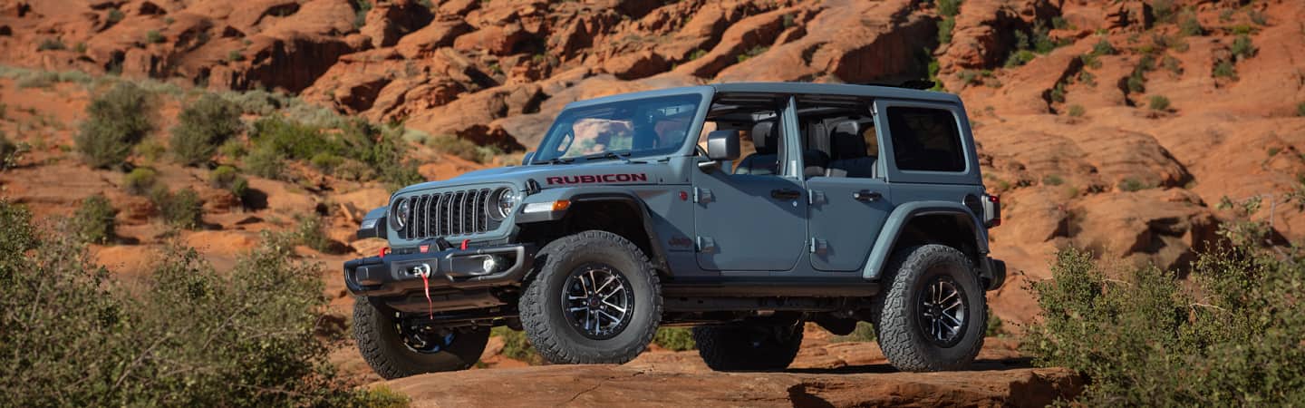 A head-on view of the 2021 Jeep Wrangler Sahara against a mountain backdrop.