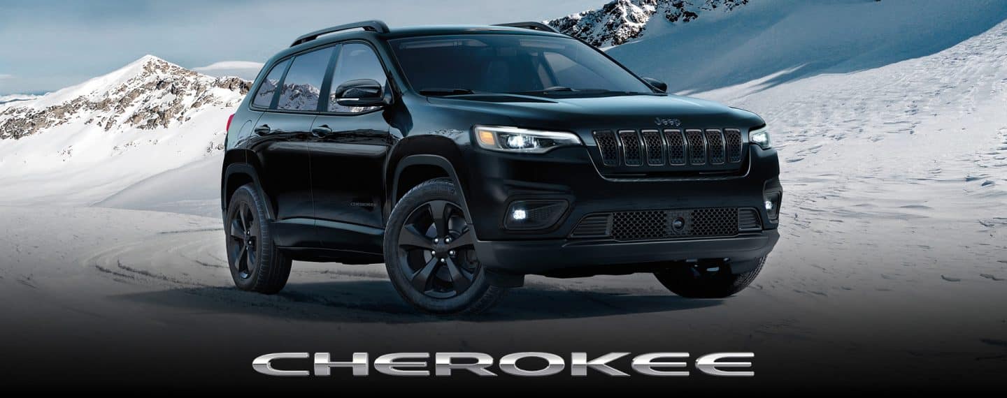 A head-on angle of a white 2023 Jeep Cherokee Trailhawk fording a stream off-road, with water splashing well above the top of the vehicle. Cherokee. The Memorial Day Sales Event logo.