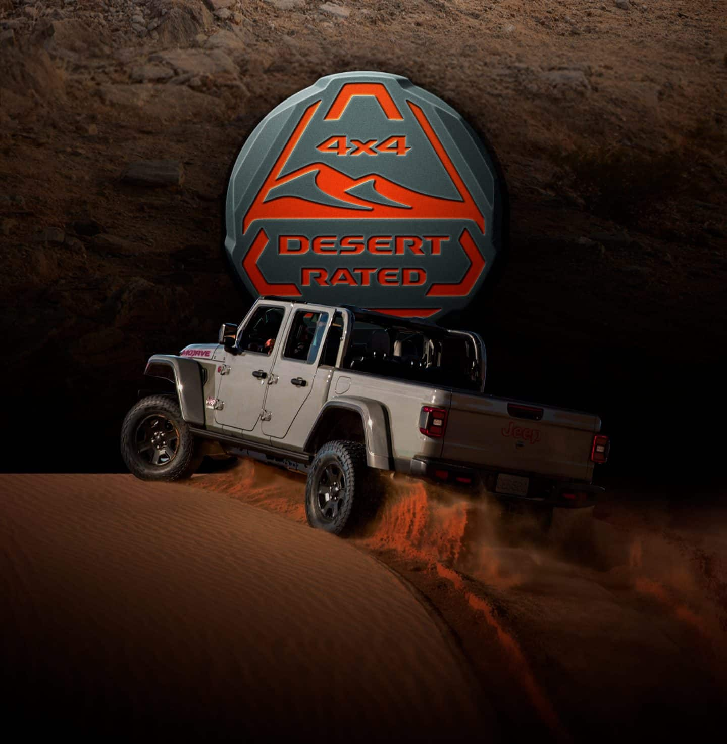 4x4 Desert Rated. The 2023 Jeep Gladiator Mojave cresting a sand dune, a cloud of dust coming from its wheels.