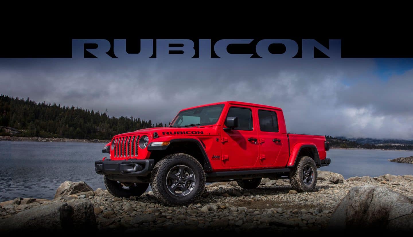 Rubicon. The 2023 Jeep Gladiator Rubicon parked on a rocky shore beside a lake.