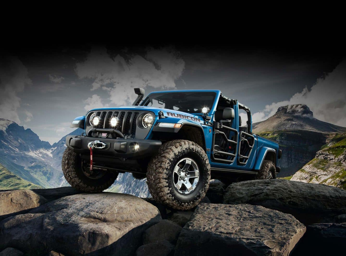 A 2023 Jeep Gladiator Rubicon modified with Jeep Performance Parts parked on a rocky incline with tube doors on, the roof removed and a bimini cover on.