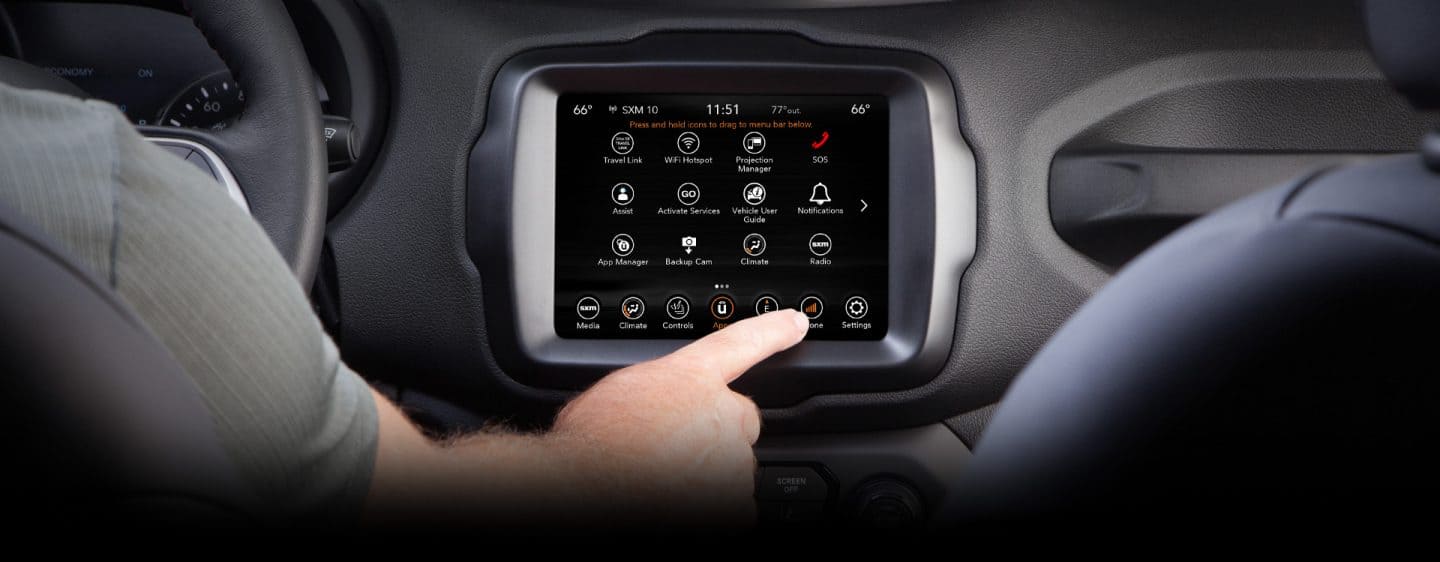Primer plano de la pantalla táctil del Jeep Renegade 2023, con la mano del conductor extendida para presionar el ícono del teléfono en la pantalla.