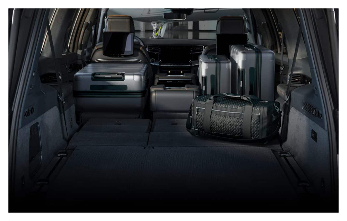 The cargo area of the 2023 Grand Wagoneer with the second and third rows folded and several suitcases in the hold.