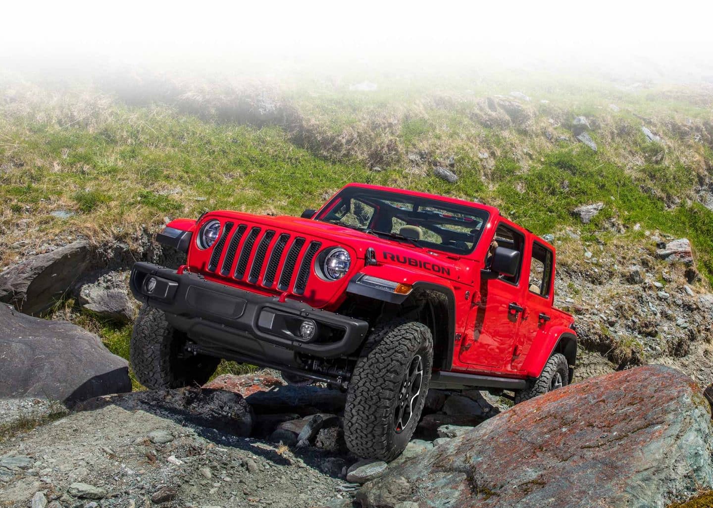 The 2023 Jeep Wrangler Rubicon being driven uphill on a steep, rocky slope.