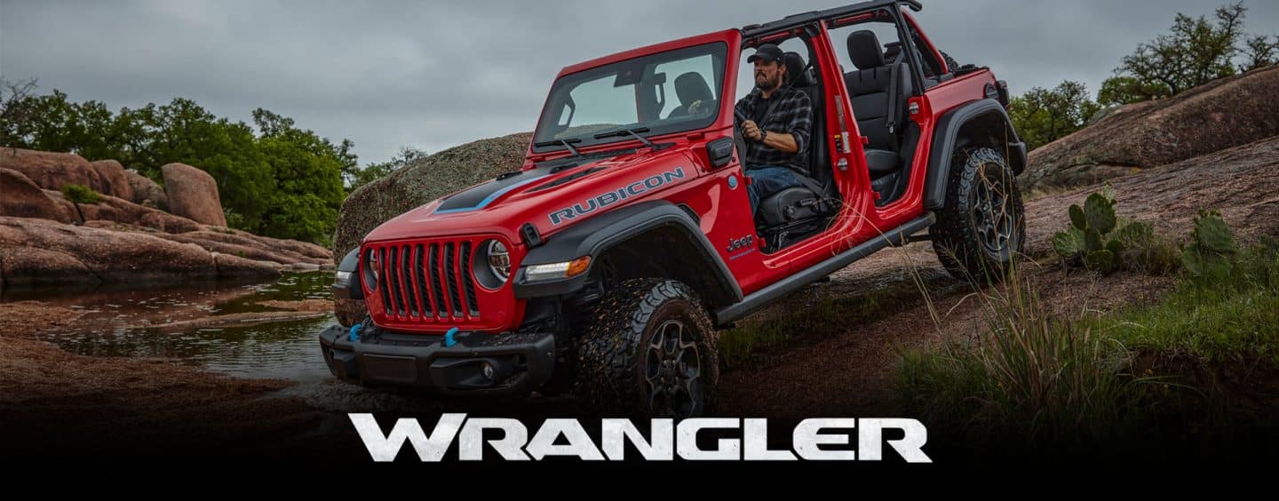 A red 2023 Jeep Wrangler Rubicon 4xe with its roof and doors removed, being driven down a steep hill off-road. Wrangler.