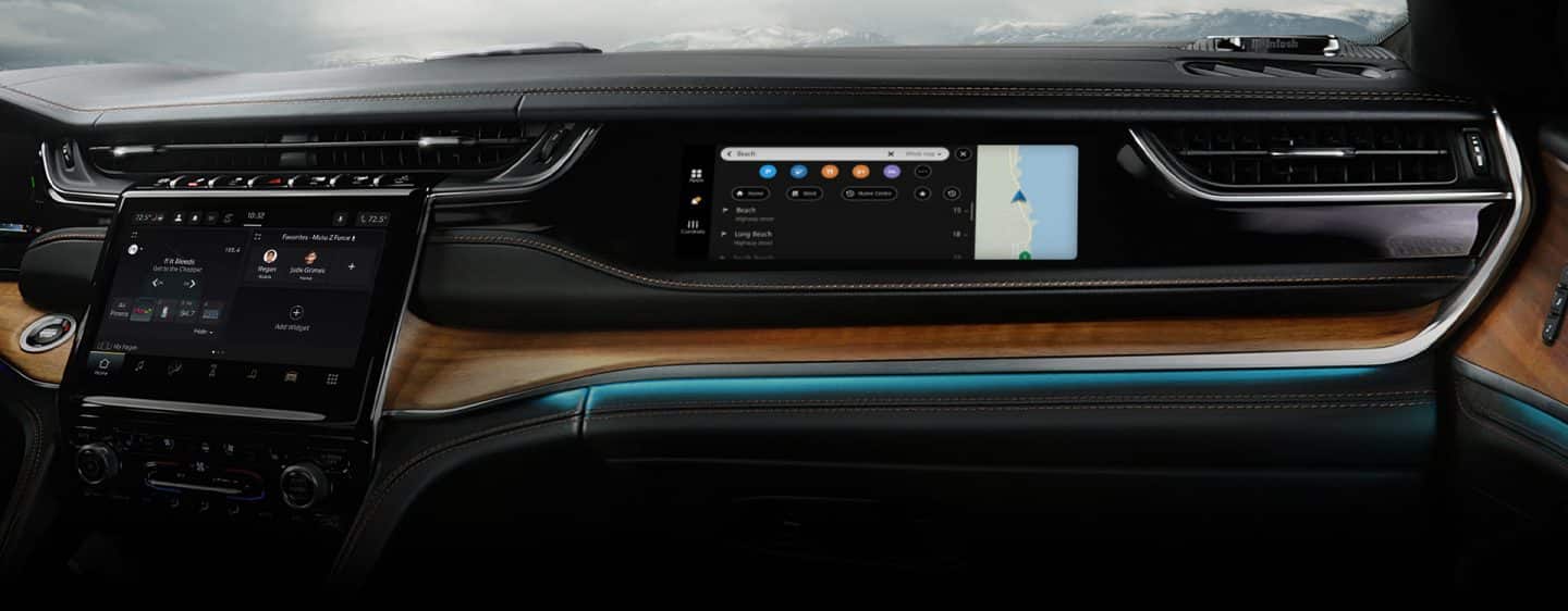 La pantalla interactiva para los pasajeros de adelante y la iluminación LED azul que recorre el tablero del Jeep Grand Cherokee Summit Reserve 2024.