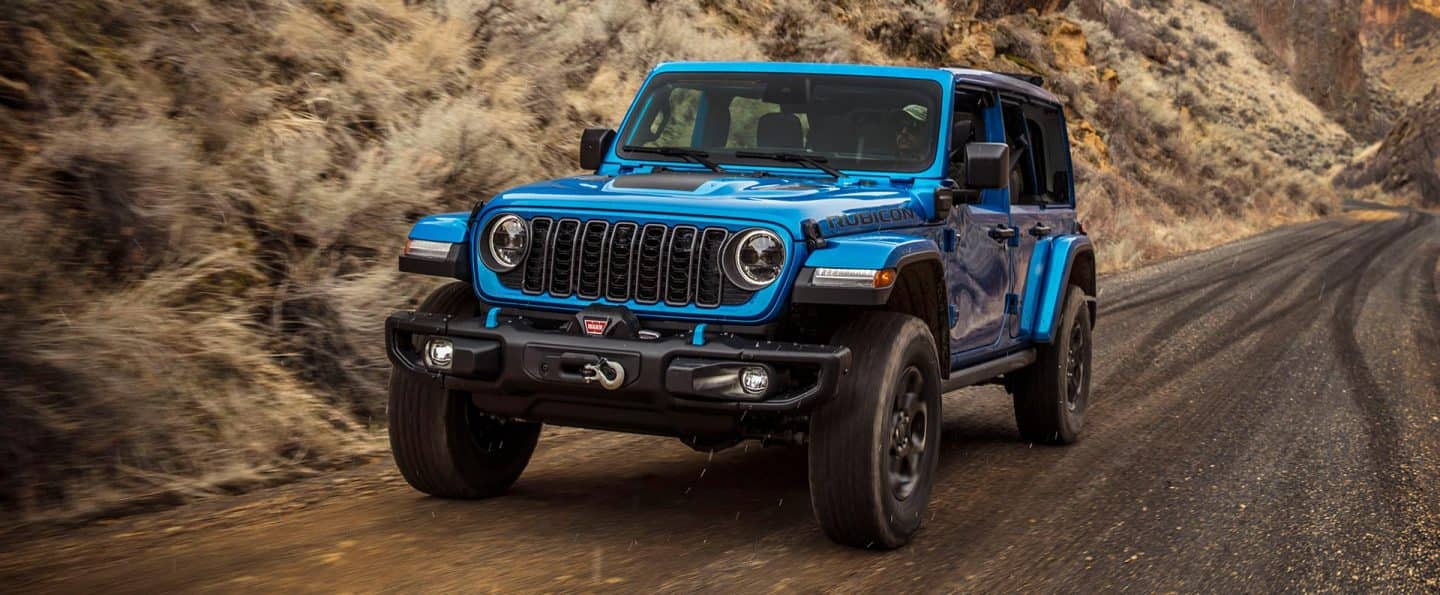 Un Jeep Wrangler4xe azul de 2025 viajando en una autopista.