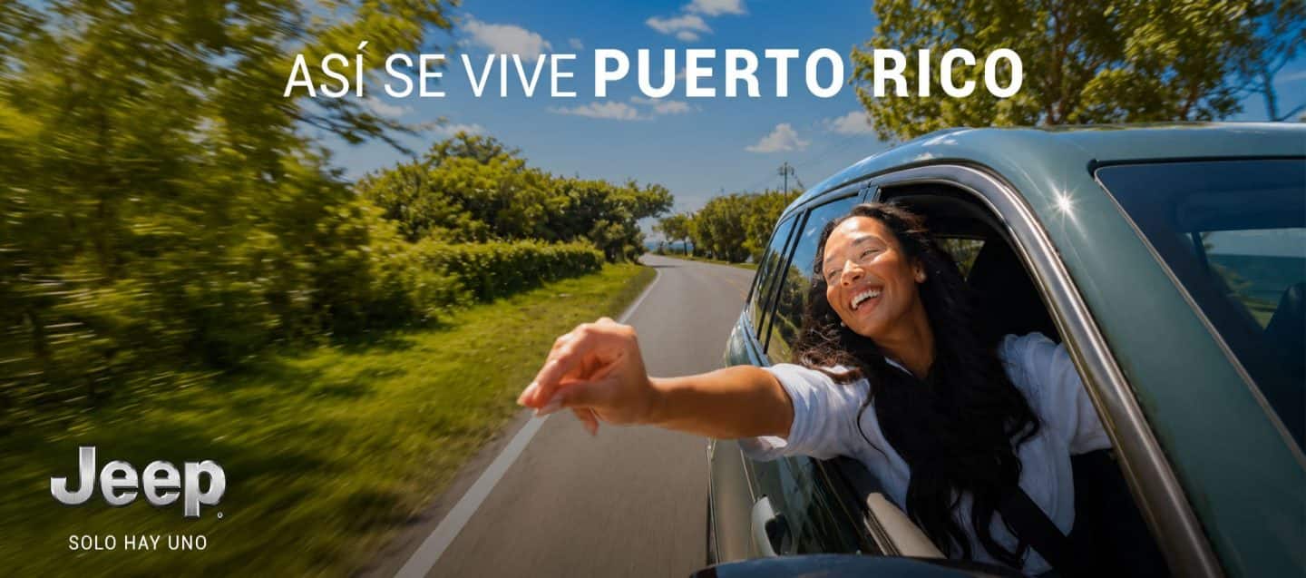Mujer dentro de la Grand Cherokee sacando la mano por la ventana.
