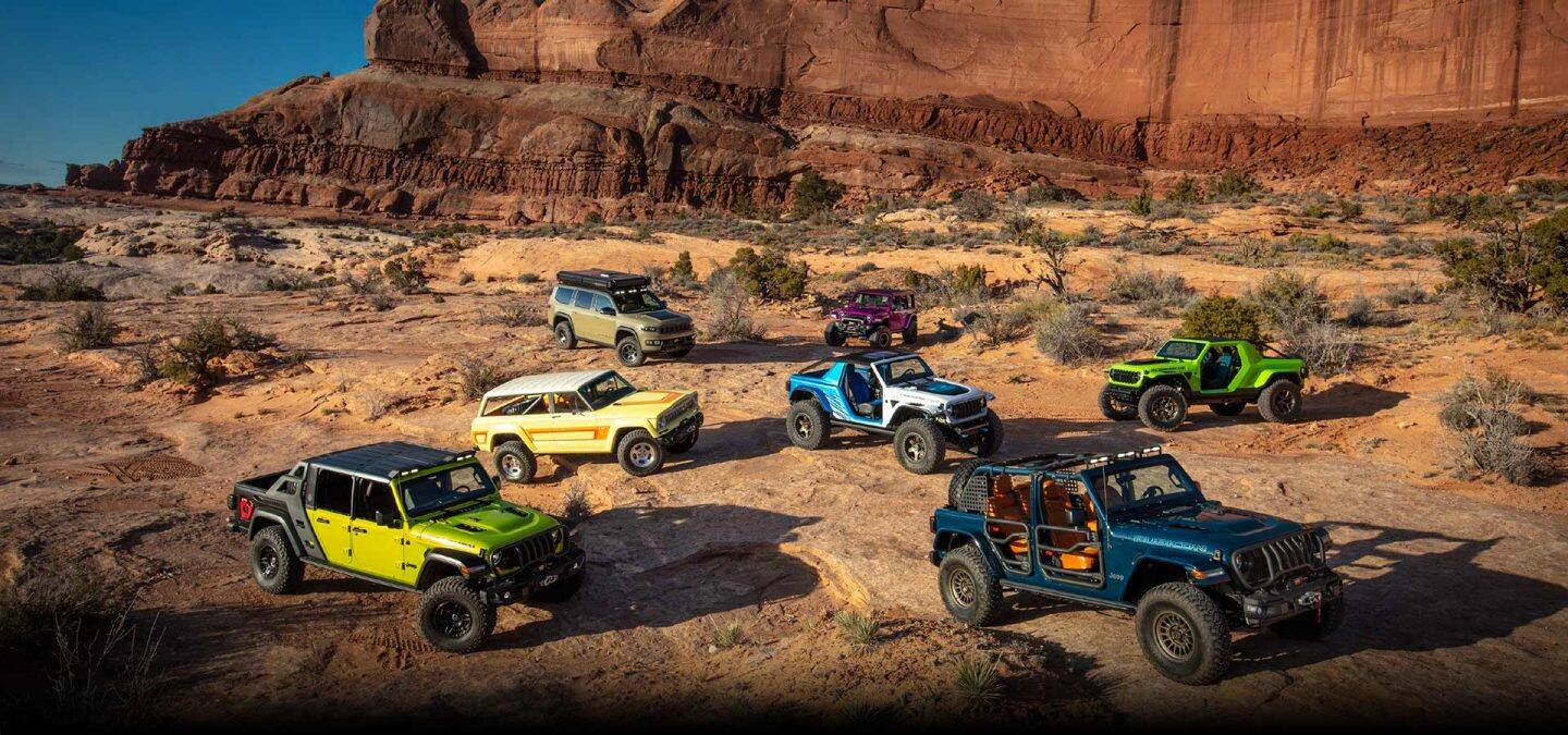 A grouping of seven Jeep Concept vehicles parked randomly in the desert.