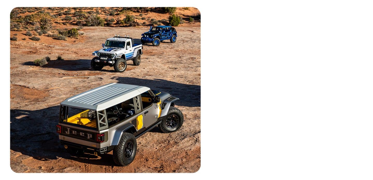 A caravan of seven Jeep Brand Concept vehicles being driven through the desert.