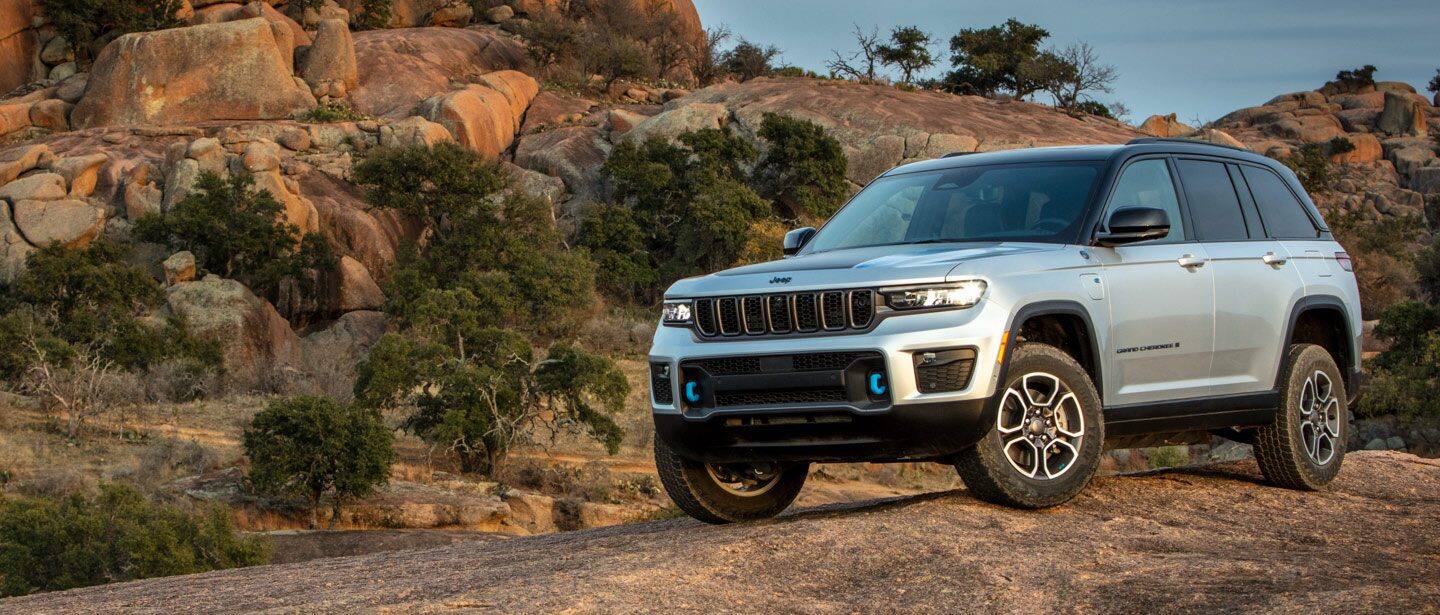 The 2023 Jeep Grand Cherokee 4xe parked off-road on a rocky plateau.