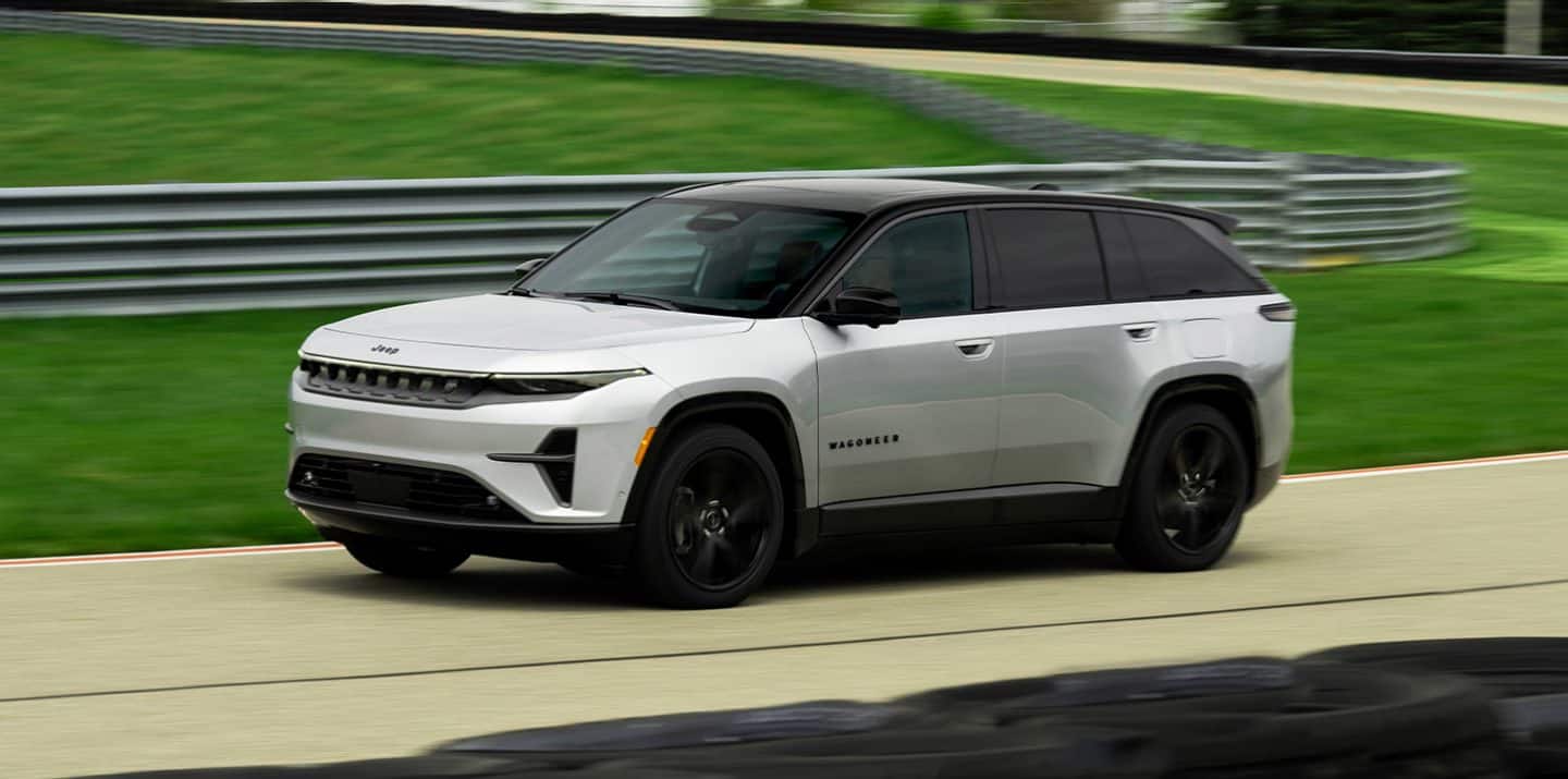 Un Jeep Wagoneer S Launch Edition 2025 blanco con techo negro andando por una pista.