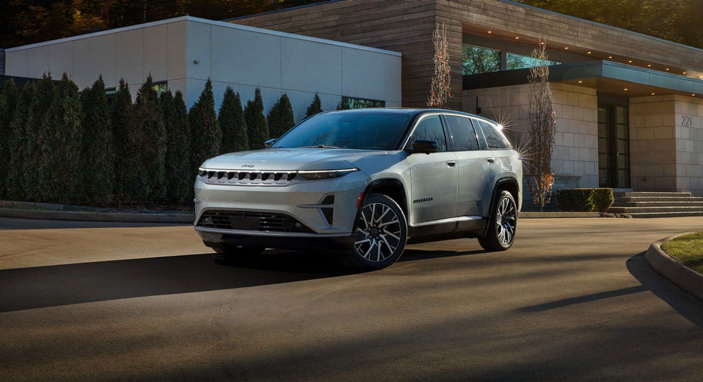 Un Jeep Wagoneer S Limited 2025 plateado en la entrada circular de un edificio comercial.
