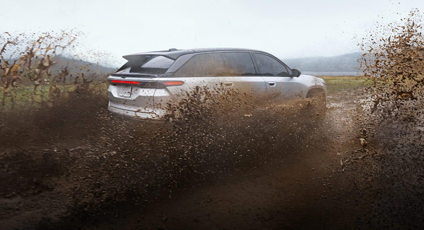 Un Jeep Wagoneer S Launch Edition 2025 plateado andando por un sendero embarrado mientras levanta barro a su paso.