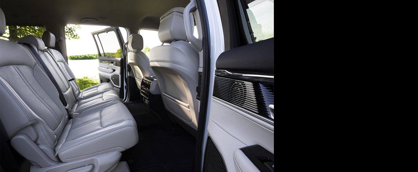 Asientos de la segunda fila del Jeep Wagoneer Series 3 2025, con la puerta trasera del lado del conductor abierta.