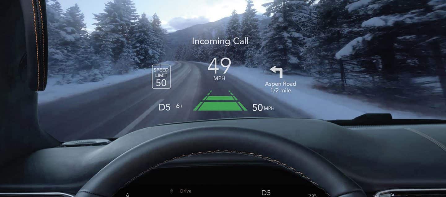 Una notificación de llamada entrante, el límite de velocidad actual, la velocidad real del vehículo y las próximas instrucciones de navegación, todo mostrado en el parabrisas del Jeep Wagoneer 2025 con Head-Up Display.