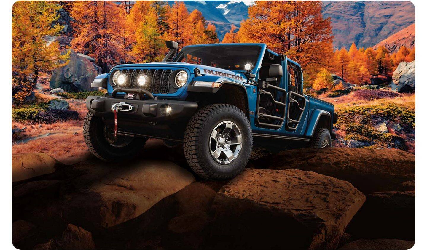 Una Jeep Gladiator Rubicon 2026 azul con puertas tubulares, trepando en modo todoterreno por una colina rocosa en las montañas.