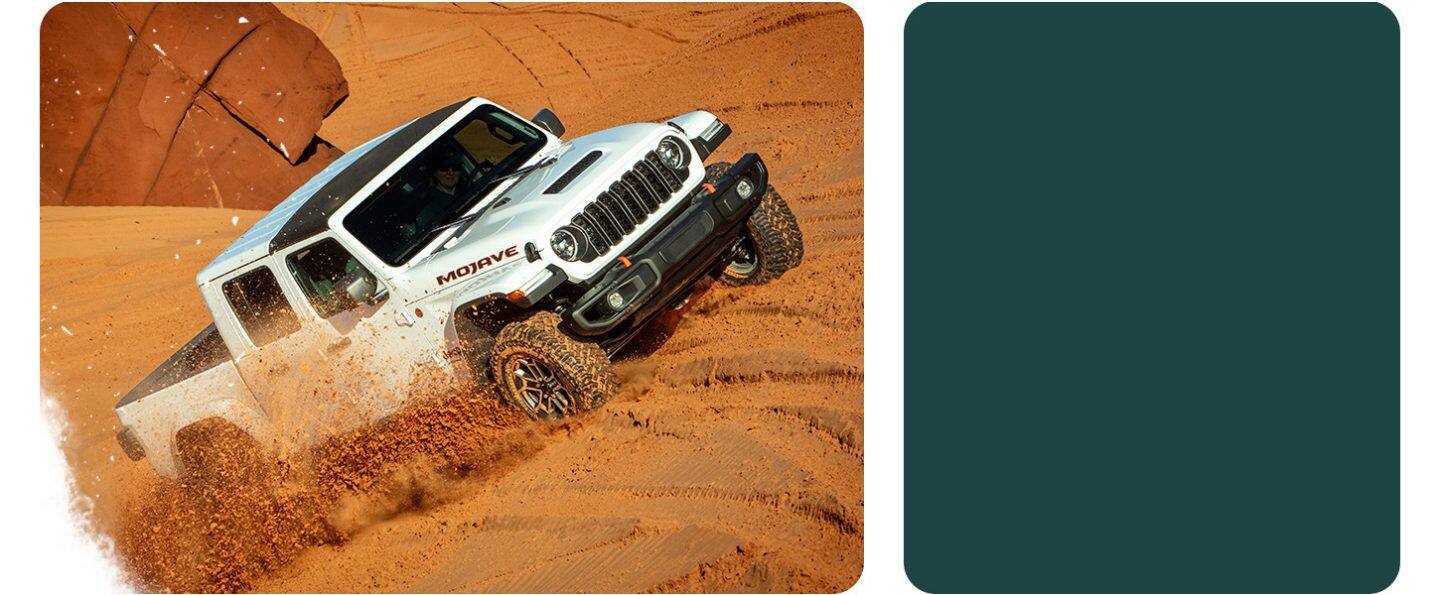 Una Jeep Gladiator Mojave X 2026 blanca con el techo removido, subiendo una colina en el desierto y levantando nubes de arena a su paso.