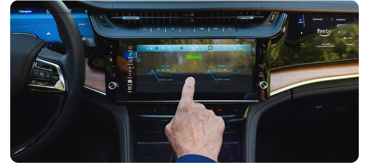 En la pantalla táctil Uconnect del Jeep Grand Cherokee Summit 2026, se observan las configuraciones de las estaciones de radio en una pantalla dividida a la izquierda y las configuraciones del control de temperatura a la derecha.