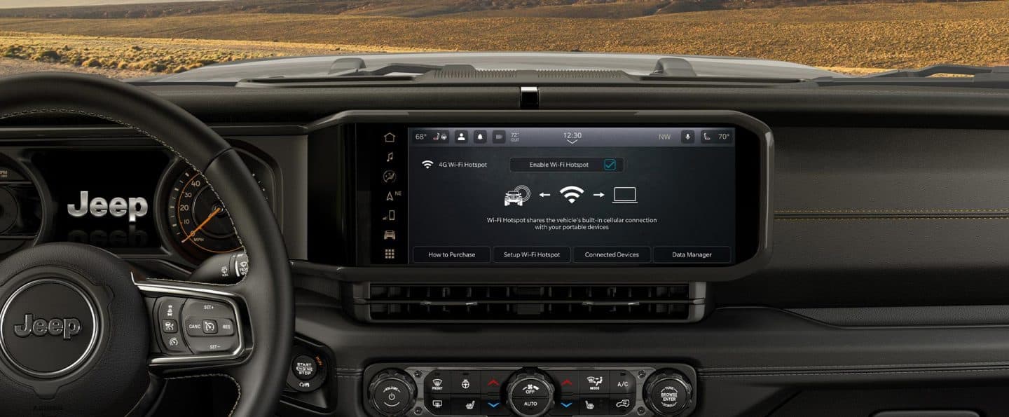La pantalla táctil de Uconnect en un Jeep Wrangler 2026, en la que se muestra una página de la guía de senderos todoterreno de Trails Offroad.