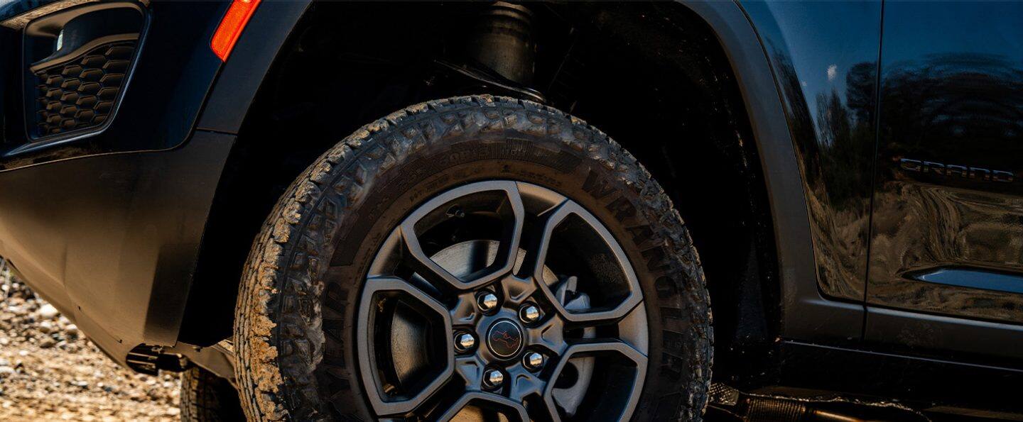 Gomas de la Jeep Grand Cherokee Trailhawk 2027 en un sendero todoterreno arenoso.