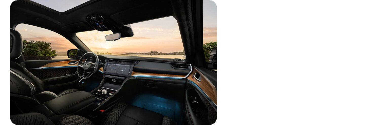 El interior de la Jeep Grand Cherokee Summit 2027, con el foco puesto en el guía, la pantalla táctil Uconnect y la consola central.