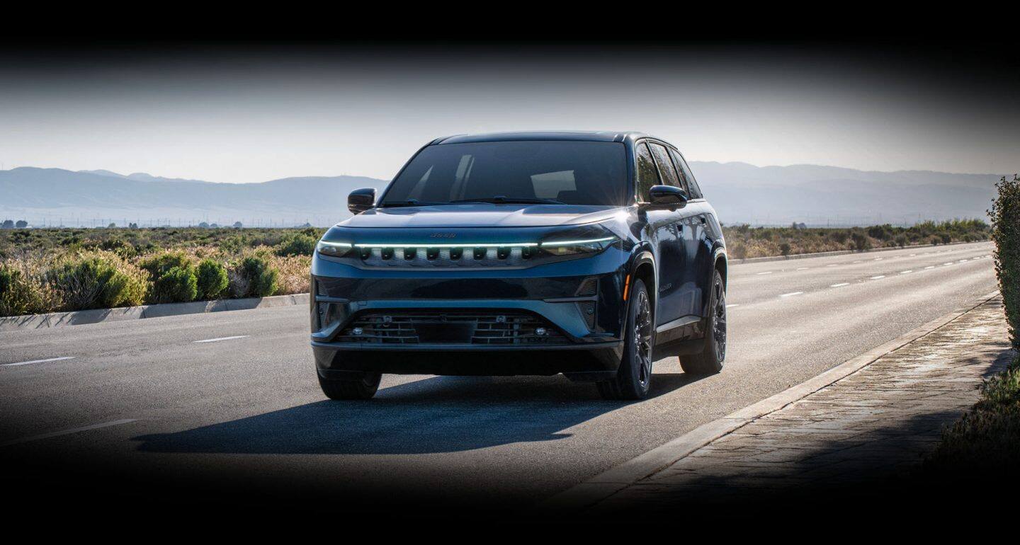 Una Jeep Wagoneer S Launch Edition 2026 azul circulando por una carretera en el desierto.