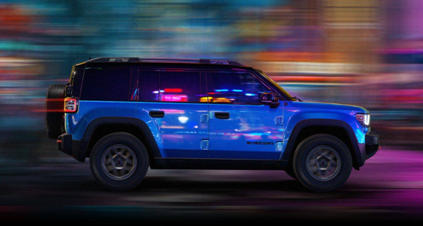 Una Jeep Recon Moab 2026 azul de perfil con el fondo difuminado para indicar que el vehículo está en movimiento.