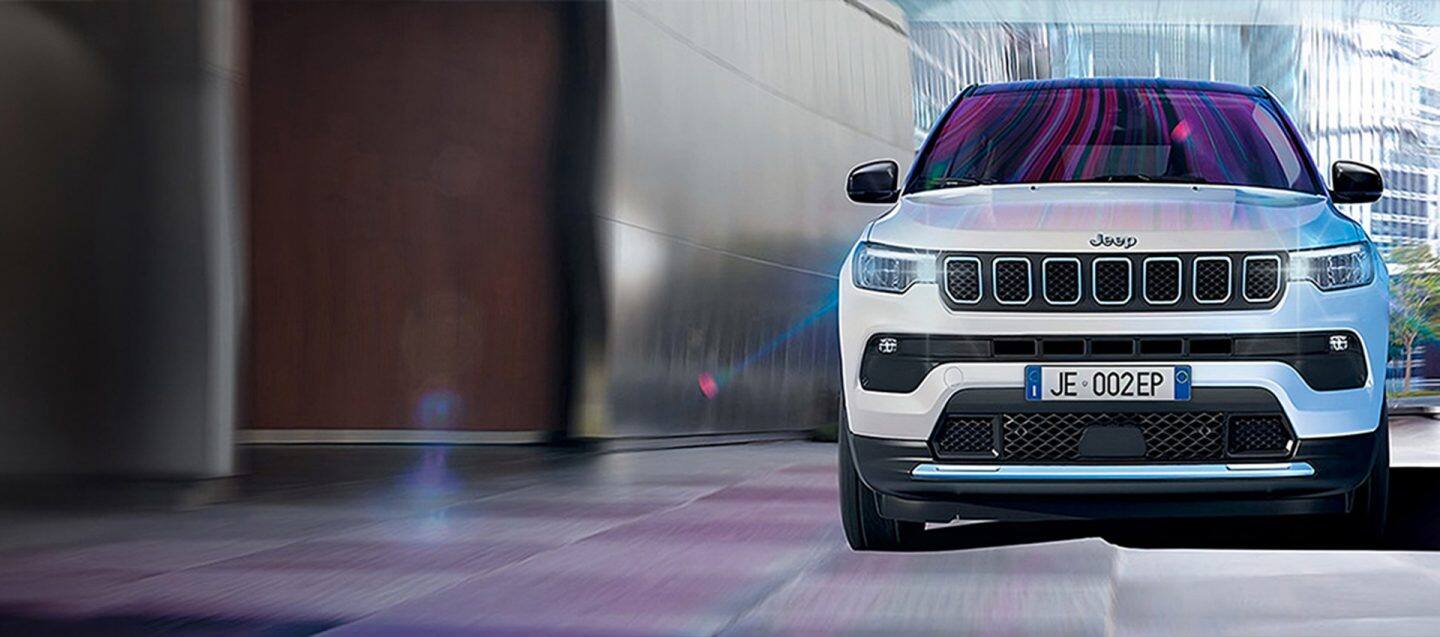 Jeep Wrangler Rubicon 4xe iz 2024. s uklonjenim vratima i krovom, vožen po pješčanoj stazi izvan ceste, s ogromnim stijenama s obje strane.