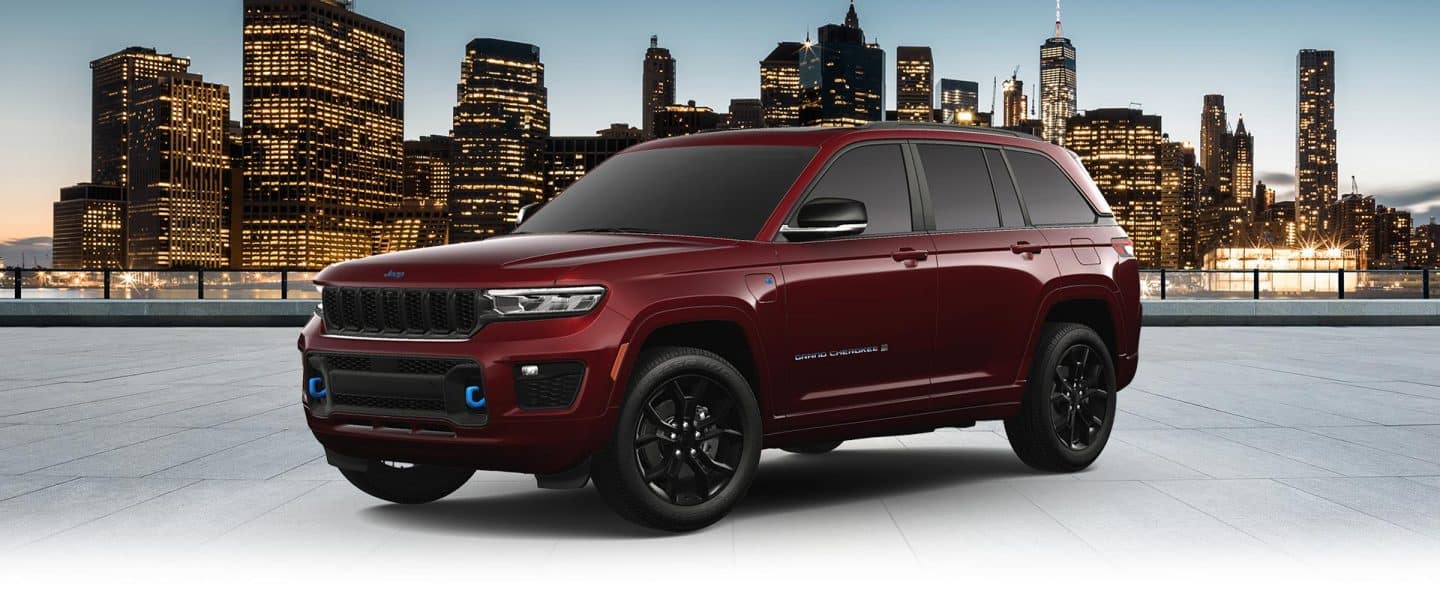 Një 2023 Jeep Wrangler Rubicon 4xe e bardhë dhe një gëlqere e gjelbër 2023 Jeep Gladiator Rubicon, të dy me dyert dhe çatitë e tyre të hequr, parkuar përballë njëri-tjetrit në rërë në këmbët e një kodre të madhe, shkëmbore. Dita e Përkujtimit të Ditës së shitjeve