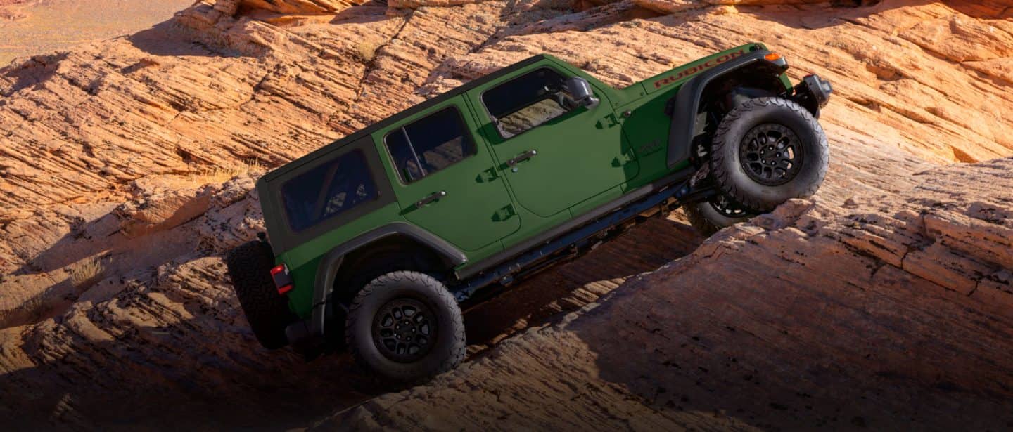 A set of six Jeep Brand Concept vehicles parked on a rocky plateau in the mountains.