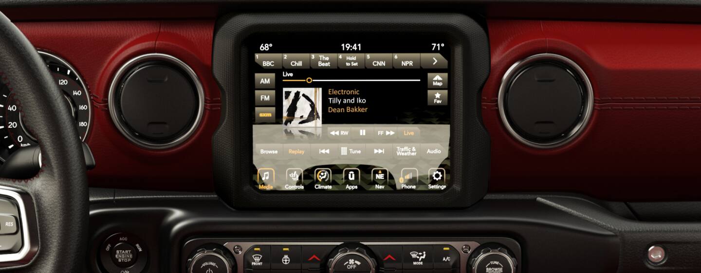 The dashboard in the 2023 Jeep Wrangler Rubicon, focusing on the steering wheel, touchscreen and climate controls.