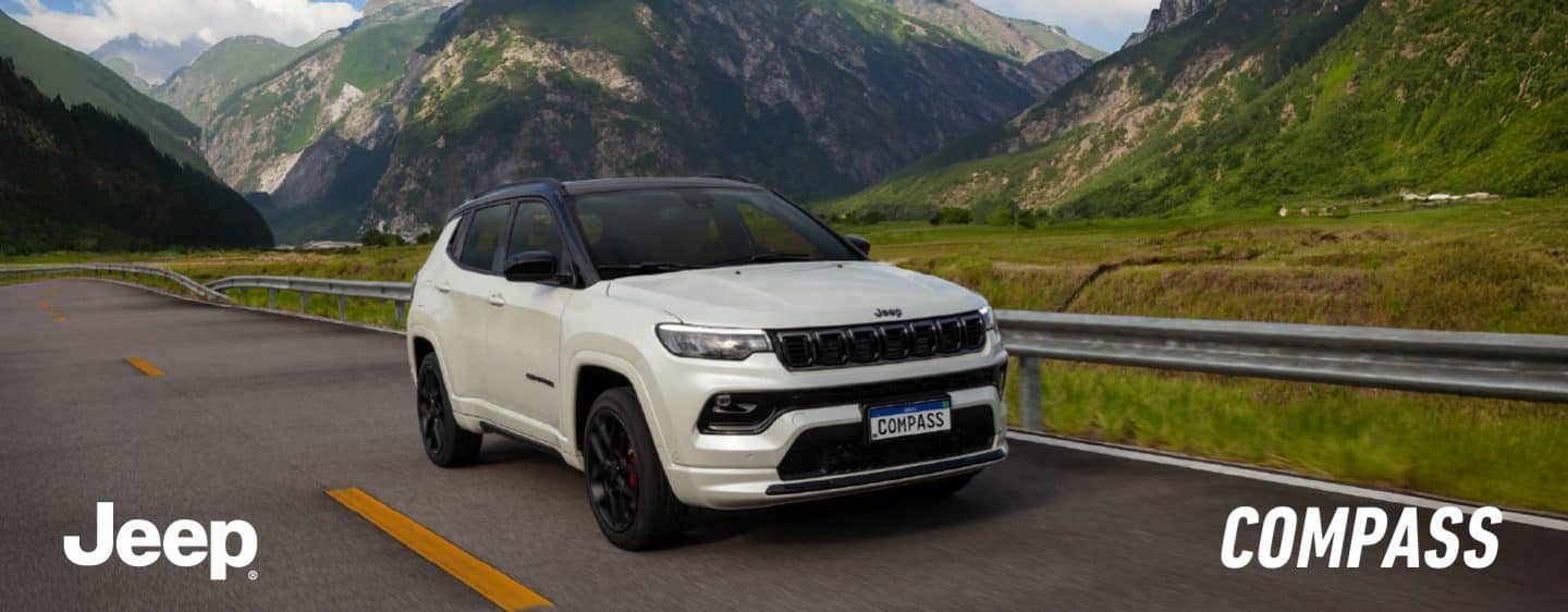 Un Jeep Compass 2023, siendo conducido en la carretera con un atardecer de fondo
