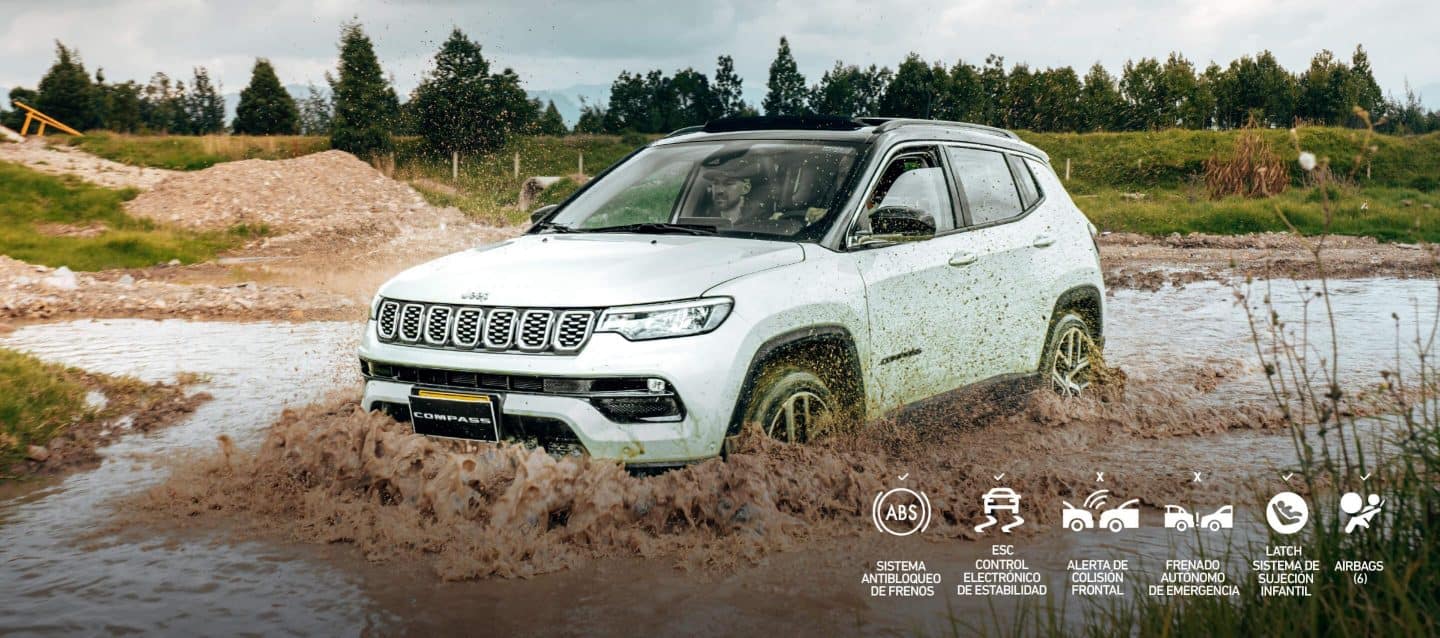 Un Jeep Compass 2025, siento conducido por terreno árido en pleno atardecer