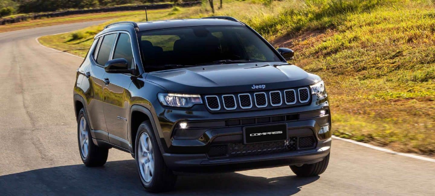 Un Jeep Compass 2023, siendo conducido en la carretera con un atardecer de fondo