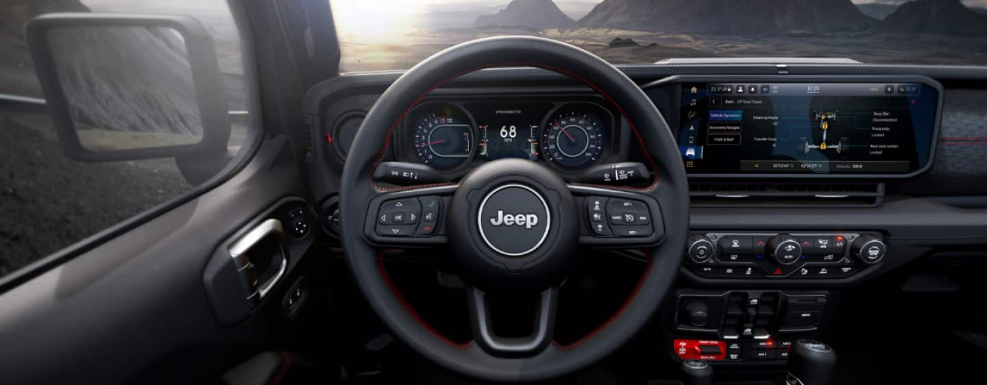 El tablero del Jeep Wrangler Rubicon 2025, con el foco puesto en el volante, la pantalla táctil y los controles de temperatura.