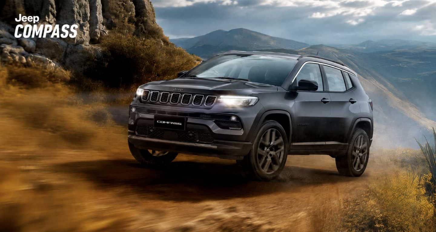 Un Jeep Compass 2023, siendo conducido en la carretera con un atardecer de fondo