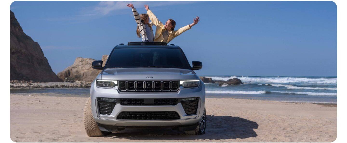 Un Jeep Grand Cherokee Summit 2026 plateado circulando por una carretera.
