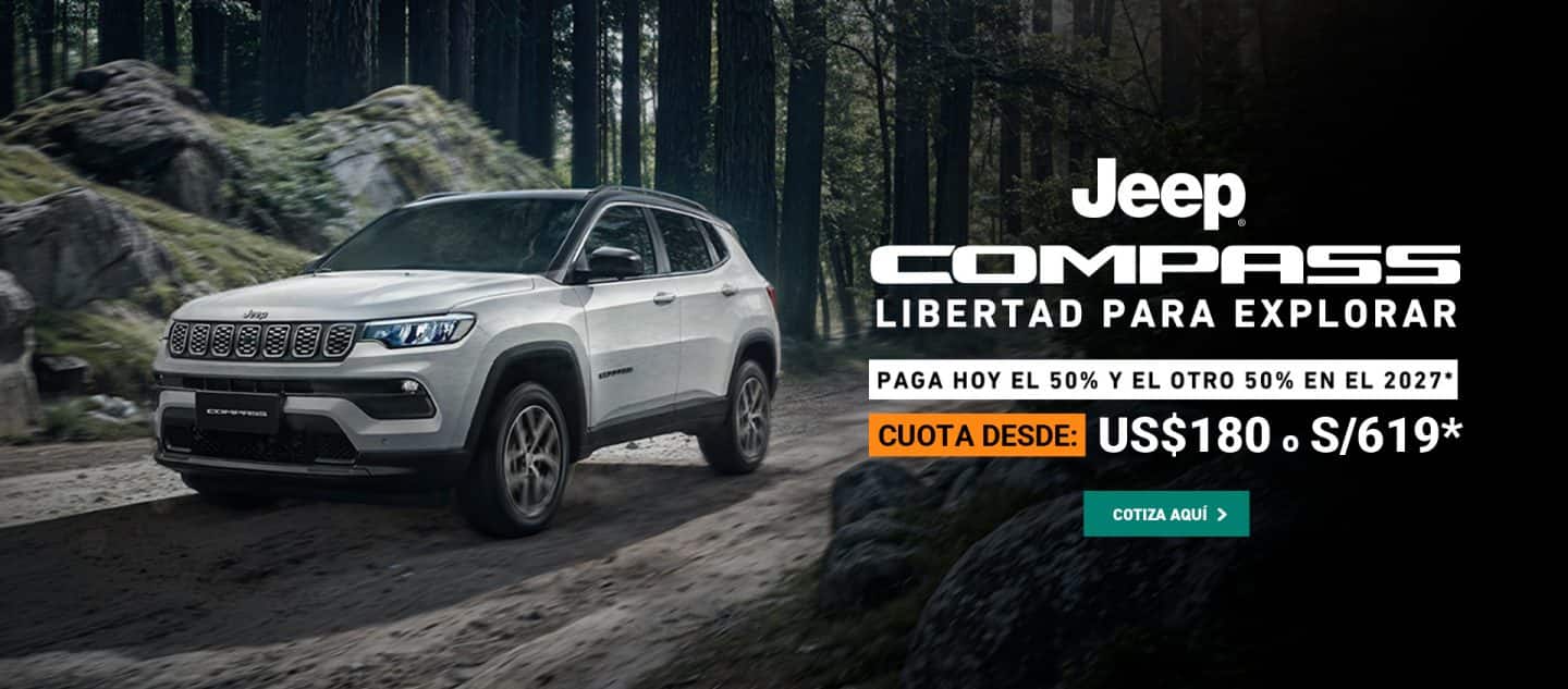 Jeep Compas color gris en una carretera en el bosque