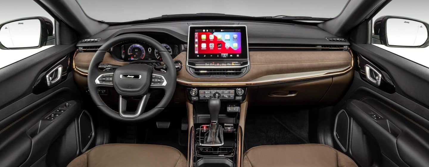 The interior of the 2023 Jeep Cherokee Altitude Lux focusing on the steering wheel, Digital Cluster Display, Uconnect touchscreen and center stack controls.