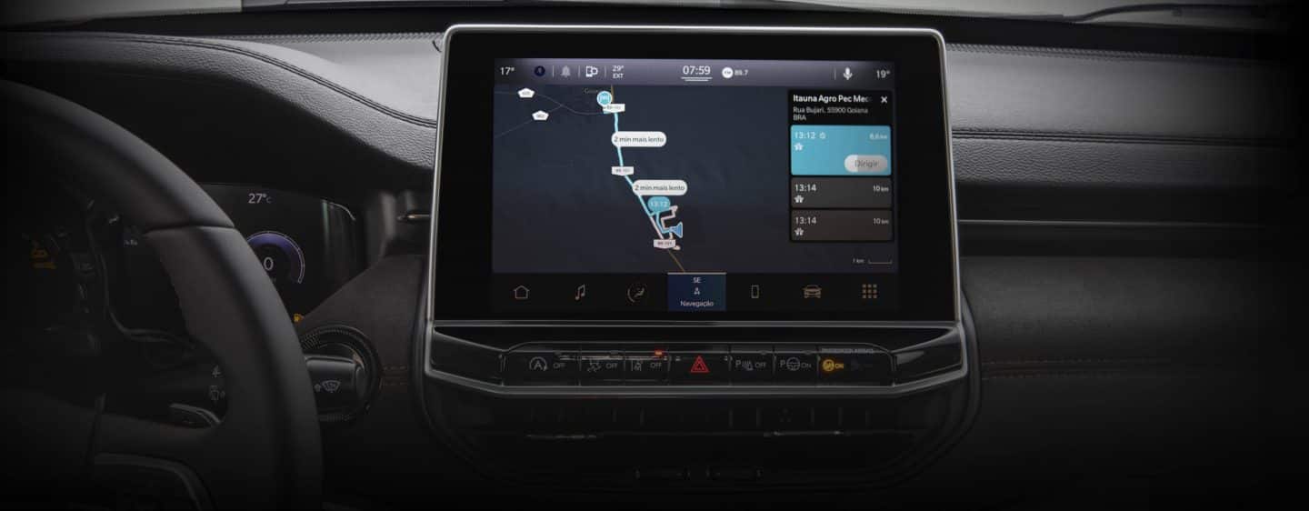 The interior of the 2023 Jeep Cherokee focusing on the steering wheel, Digital Cluster and Uconnect touchscreen, with the touchscreen displaying a variety of menu options.