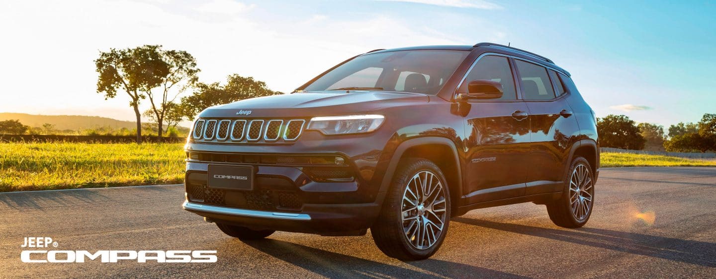 Un Jeep Compass 2023, siendo conducido en la carretera con un atardecer de fondo