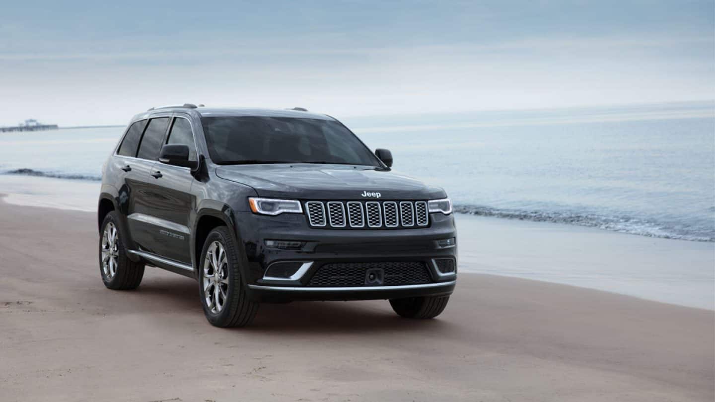 Jeep Grand Cherokee parked on a beach.