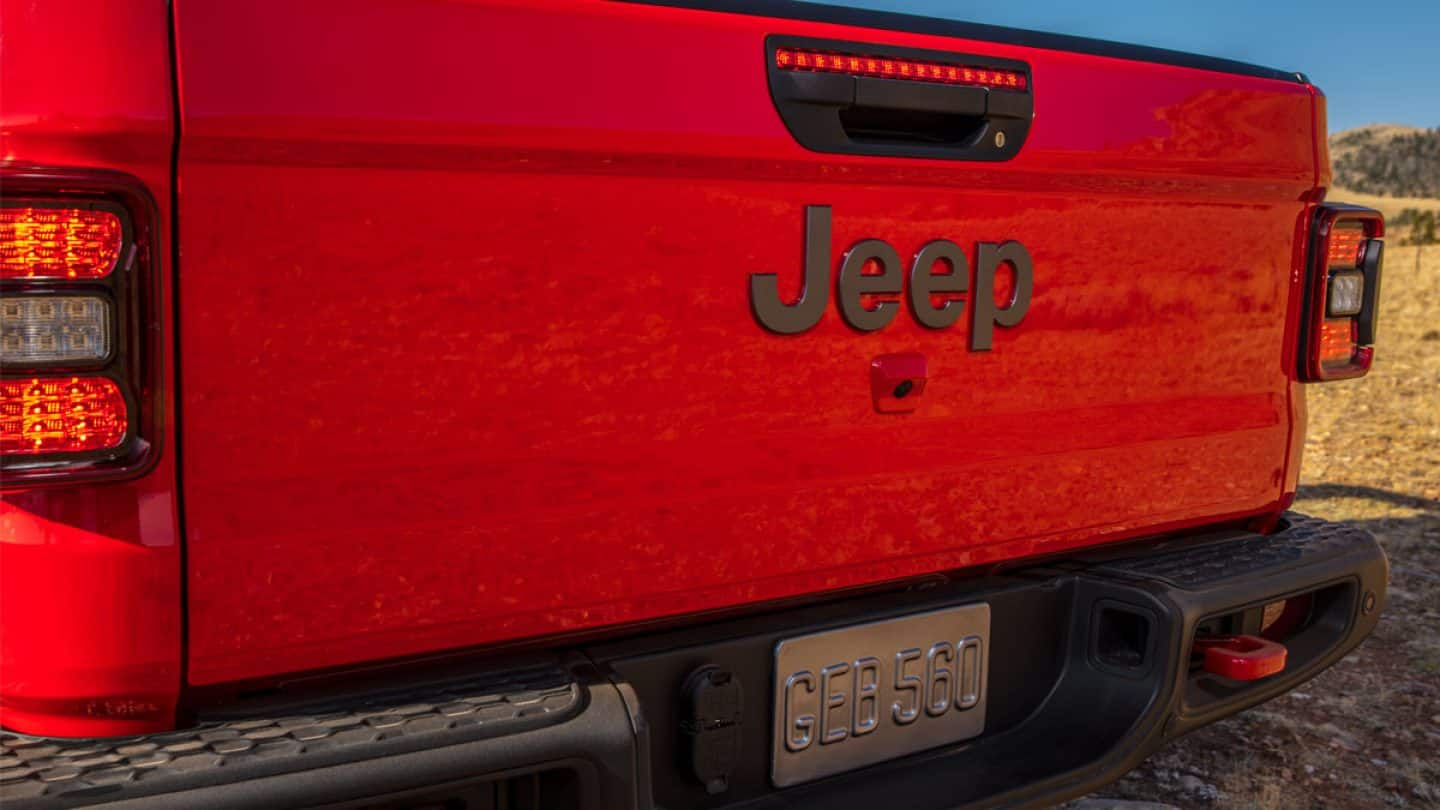 A red jeep parked in front of a louis vuitton store photo – Free