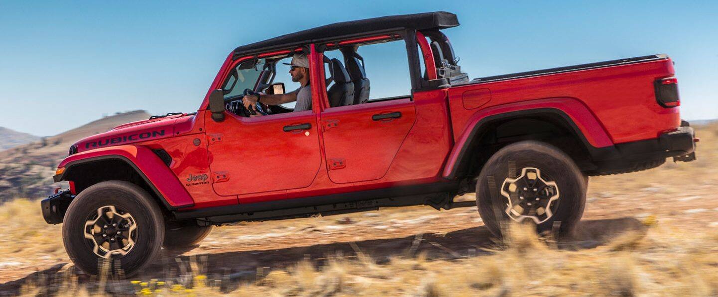 The 2021 Jeep Gladiator Rubicon being driven through scrubby desert terrain.