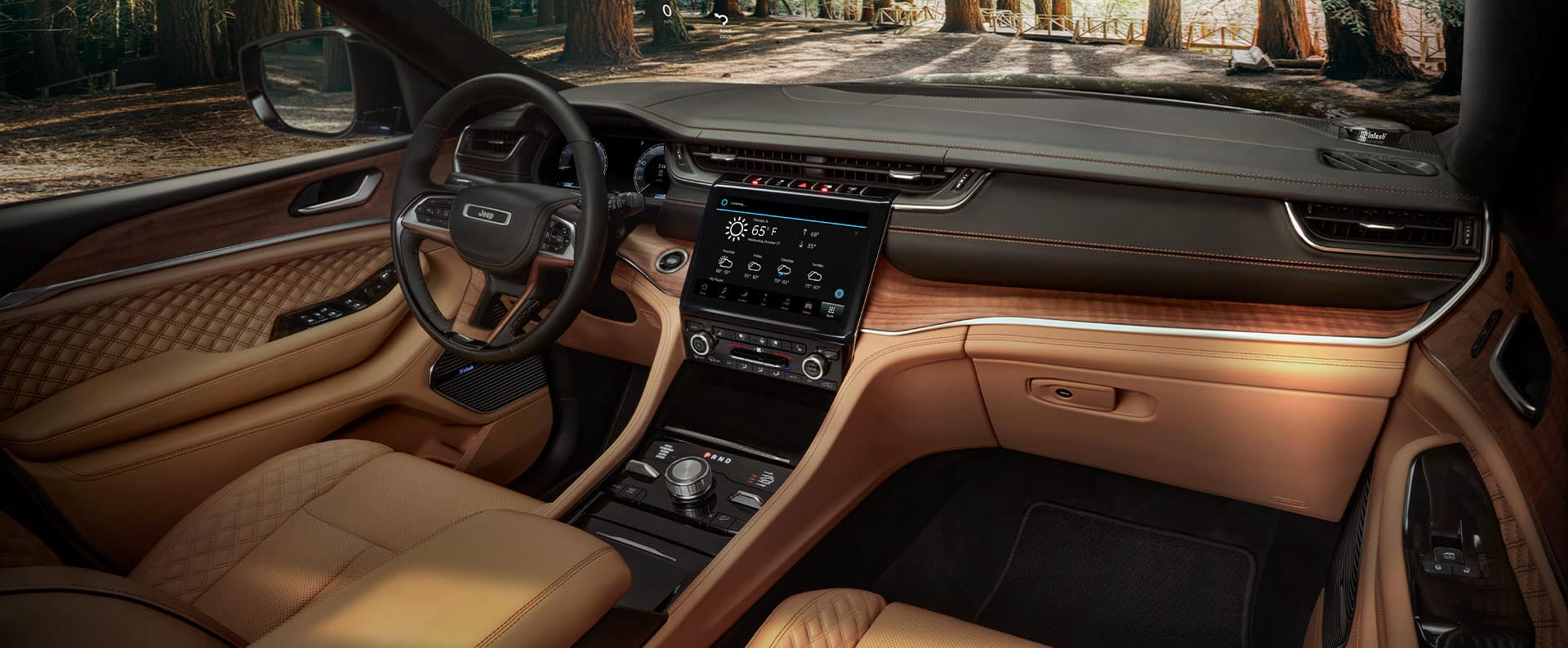 The interior of the 2021 Jeep Grand Cherokee L Summit Reserve, focusing on the front seats, entertainment center and dashboard.