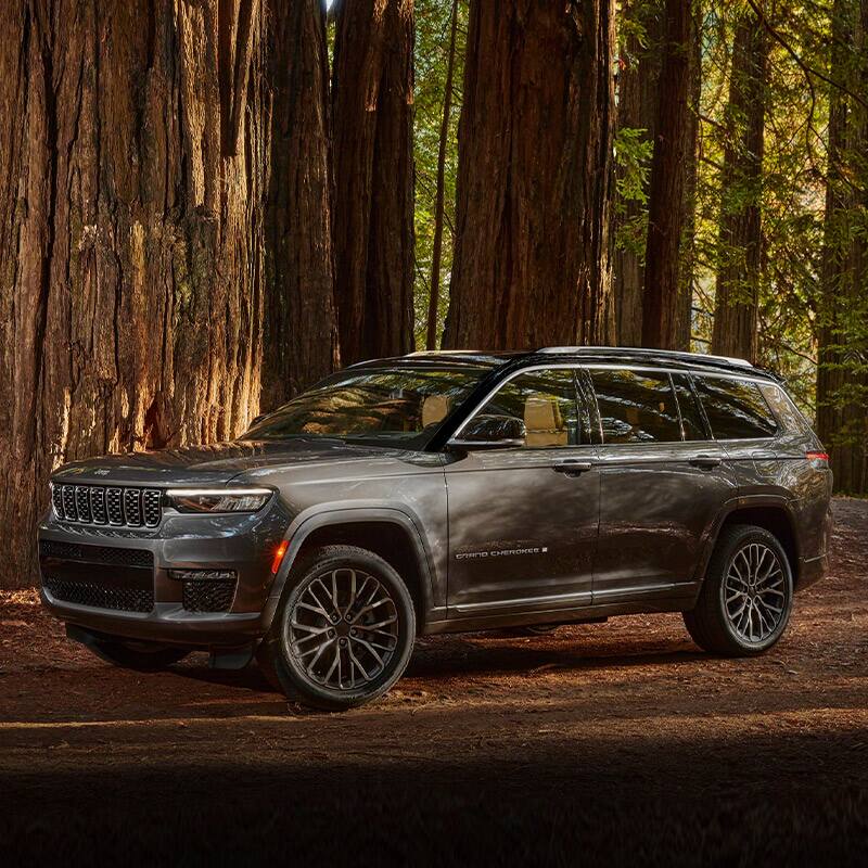 The 2021 Jeep Grand Cherokee L Summit Reserve parked on a dirt track in the woods.